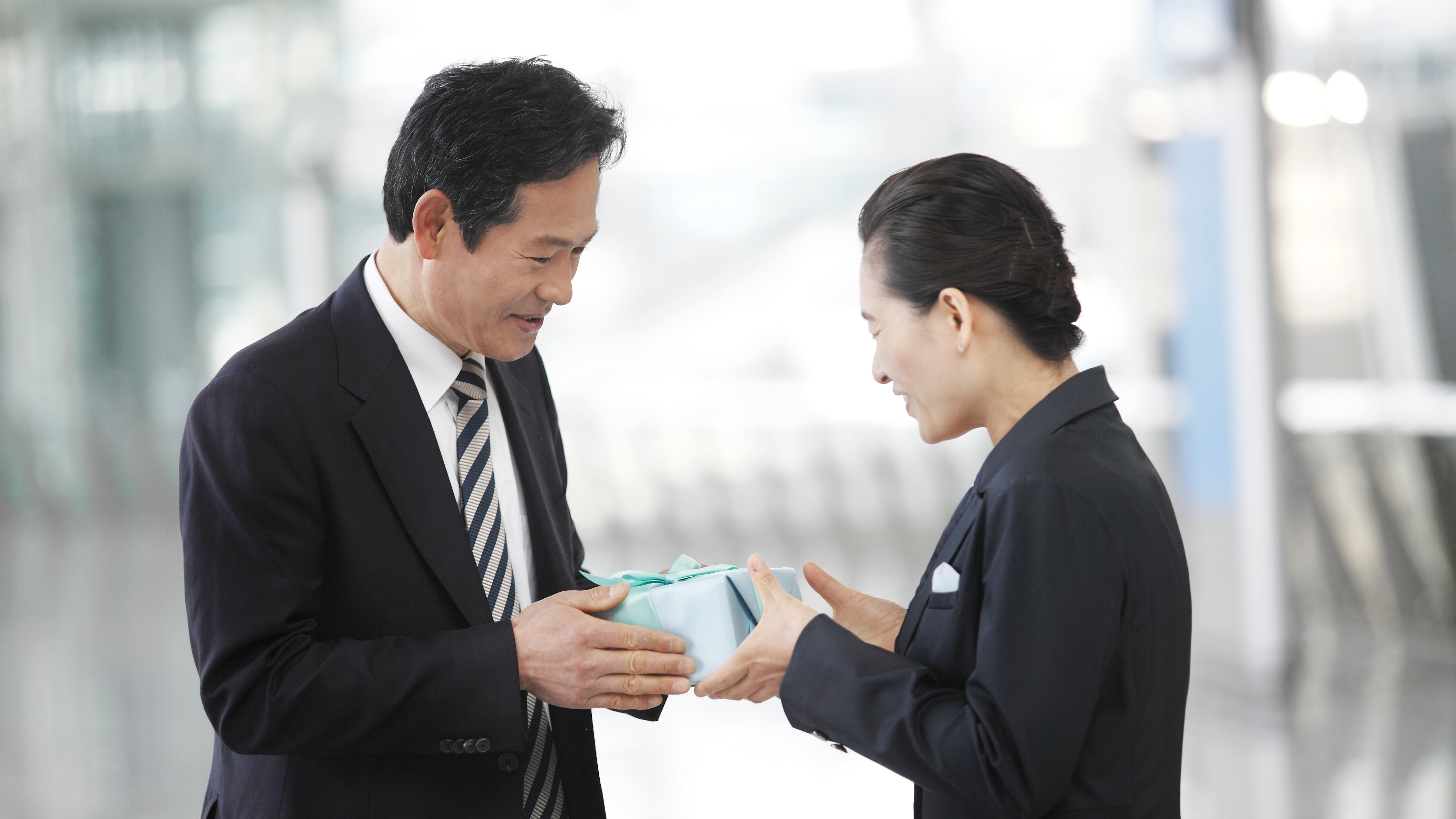 Business man giving business woman a gift
